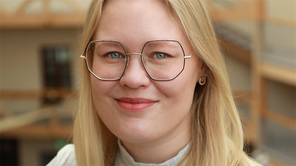 En kvinna med glasögon och vit tröja