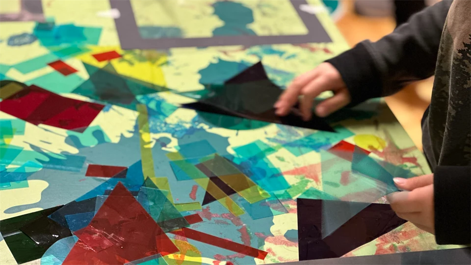 A childs hands playing with cut outs in different colors