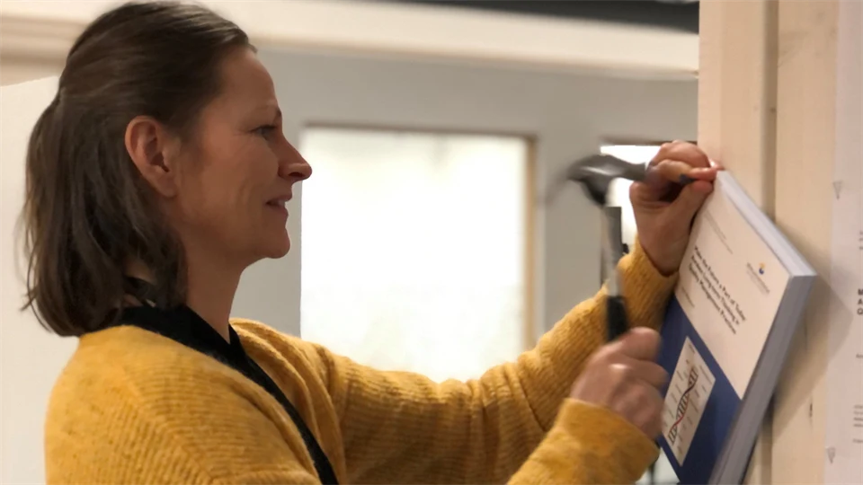 En kvinna spikar upp en avhandling