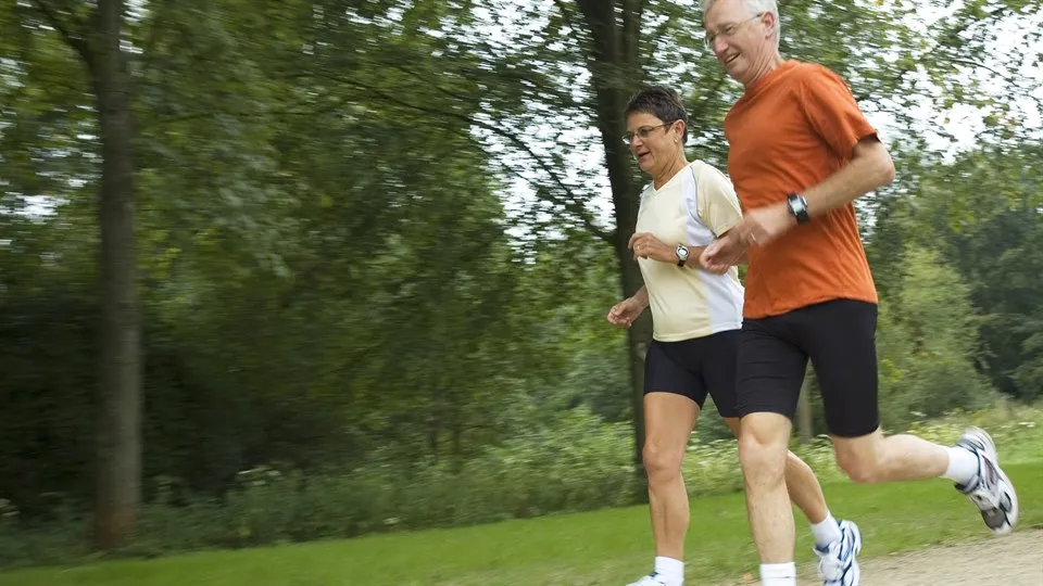 man och kvinna joggar i naturen