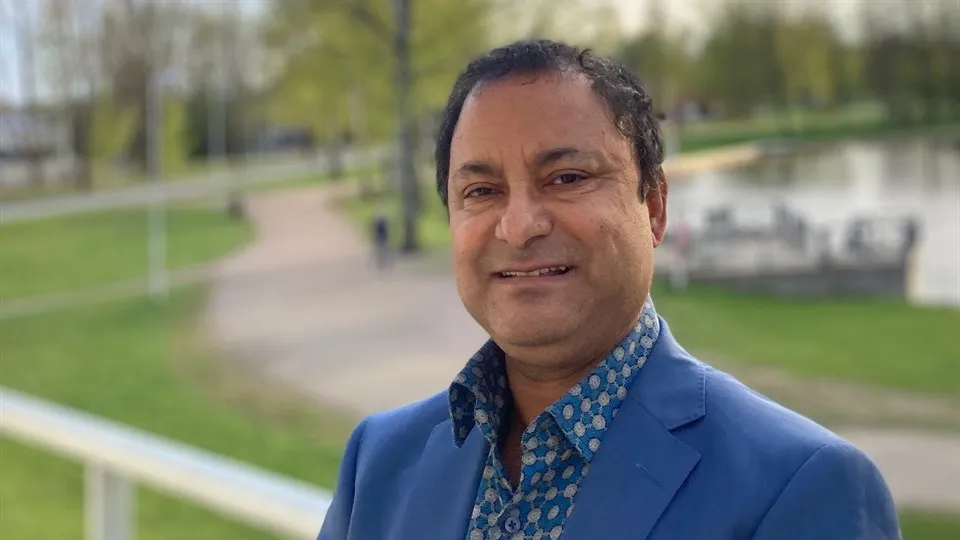 Koustuv Dalal står utomhus framför en parkmiljö.