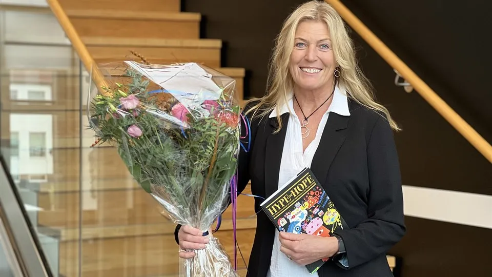 En kvinna hållandes blommor och en bok