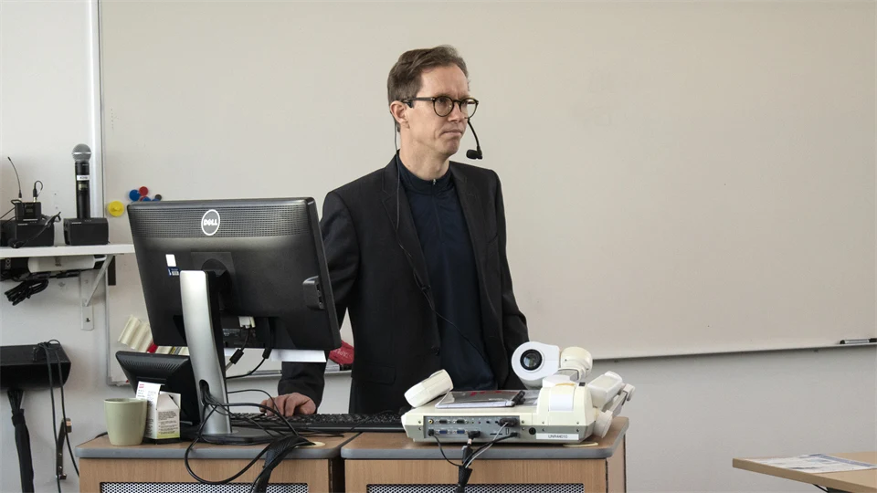 A man stands and lectures.