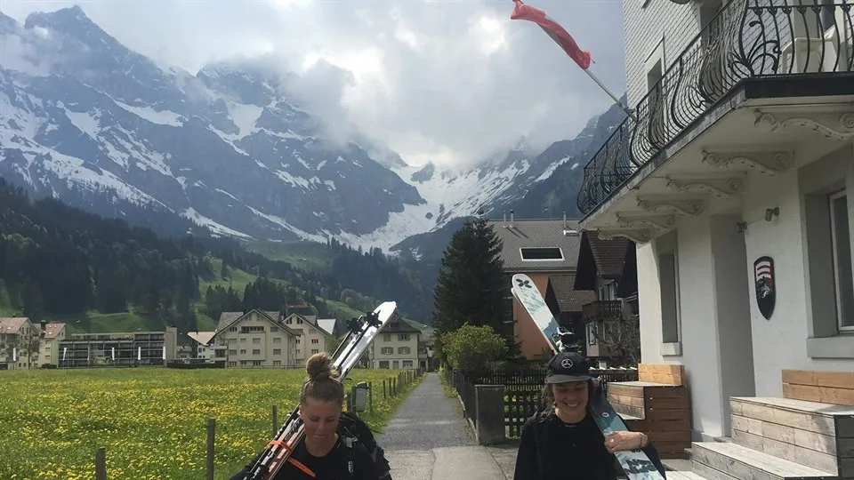 Alexandra och Andrea bär alpinskidor i Luzern