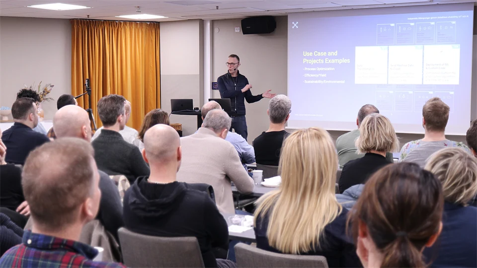 A man stands in front of an audience and speaks.
