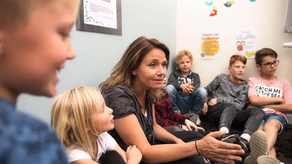 Lärare och barn har samling i skolan