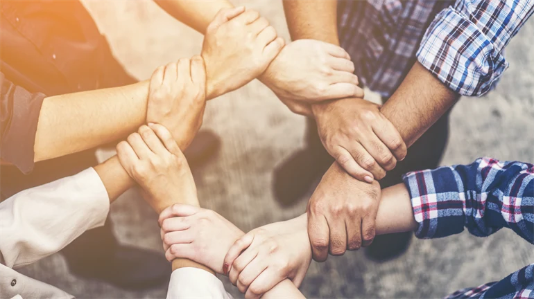Eight hands that hold on to the next wrist to make a safe circle.