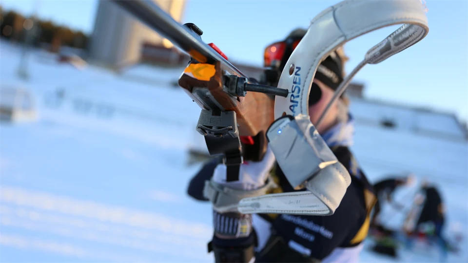 Close-up of a biathlon rifle and a biathlon athlete