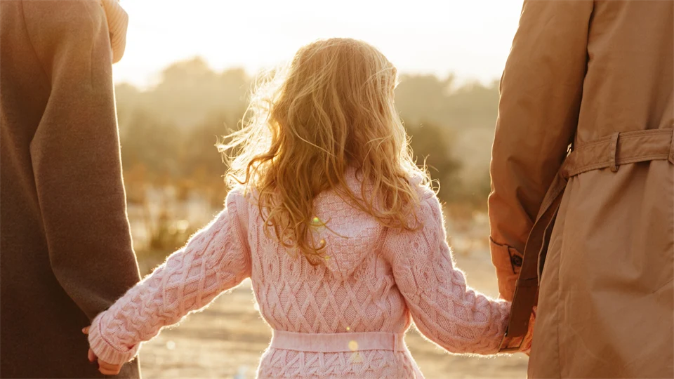 a woman, a child a man, seen from behind
