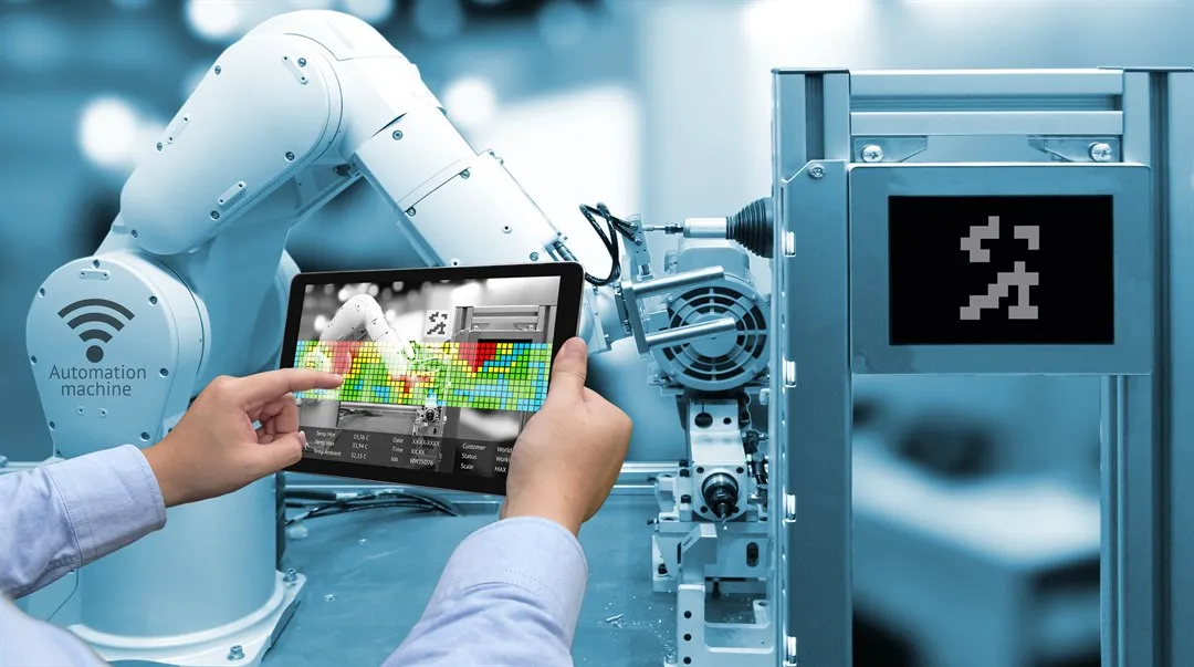 Robotarm i industri och två människohänder som håller en läsplatta.