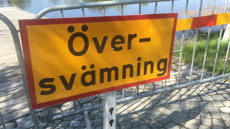 Gul skylt med texten "Översvämning" i svart