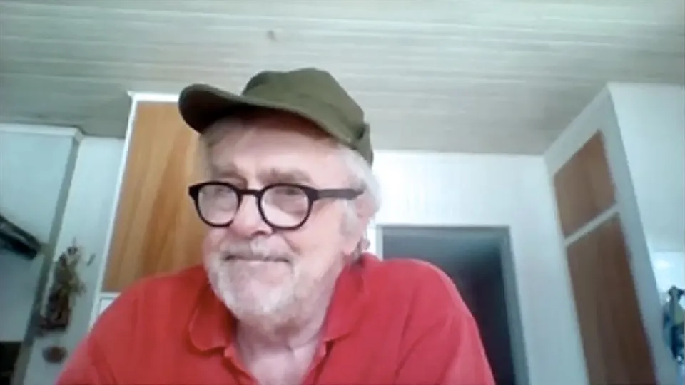 Man med keps sitter i ett kök