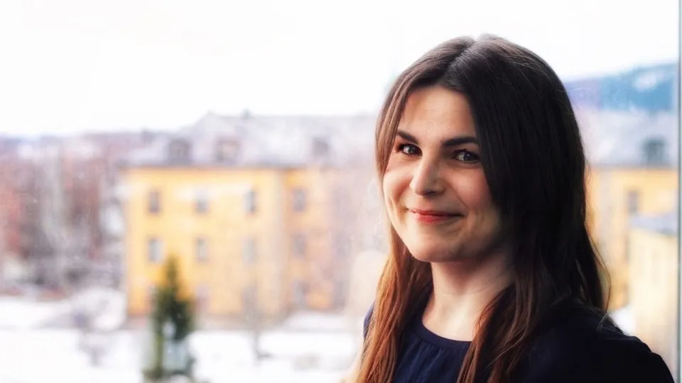 Marie-France tittar in i kameran med campus Östersund i bakgrunden