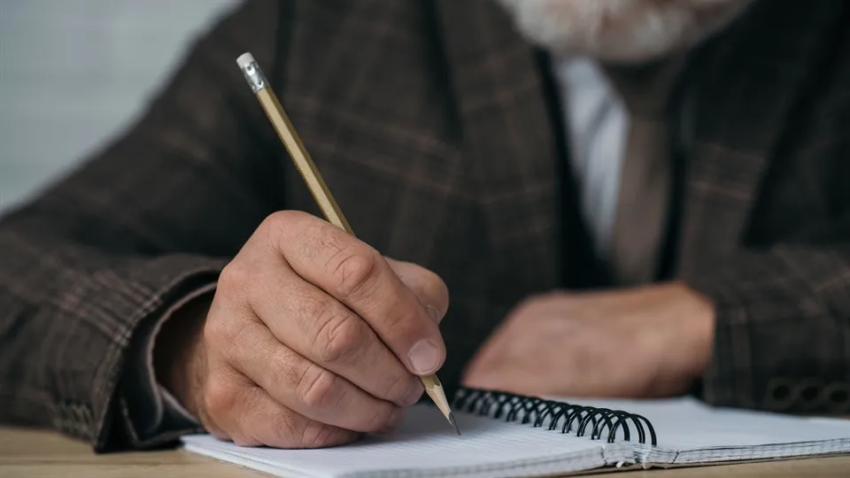 Man skriver i bok