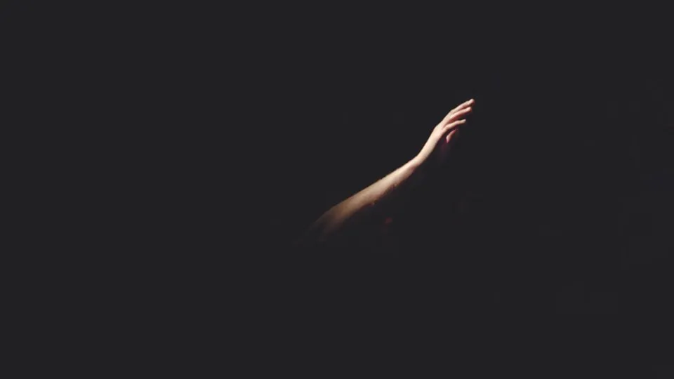 Hand begging for help in the darkness