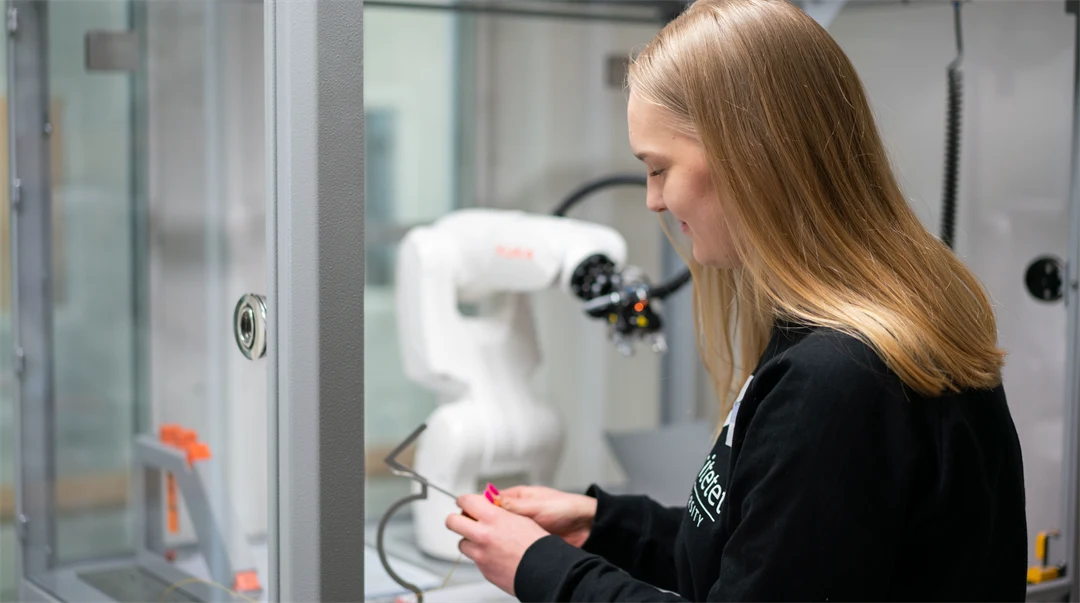 Kvinna som arbetar med en robotarm