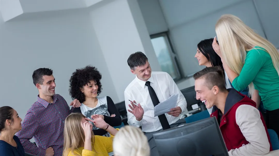 Grupp med studenter med manlig lärare i datorsal