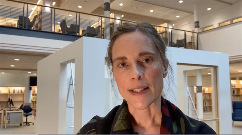 Kvinna framför ett vitt, kubformat rum