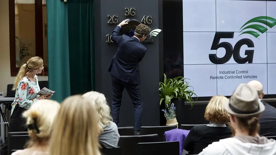 Man turning a big switch to launch 5G.