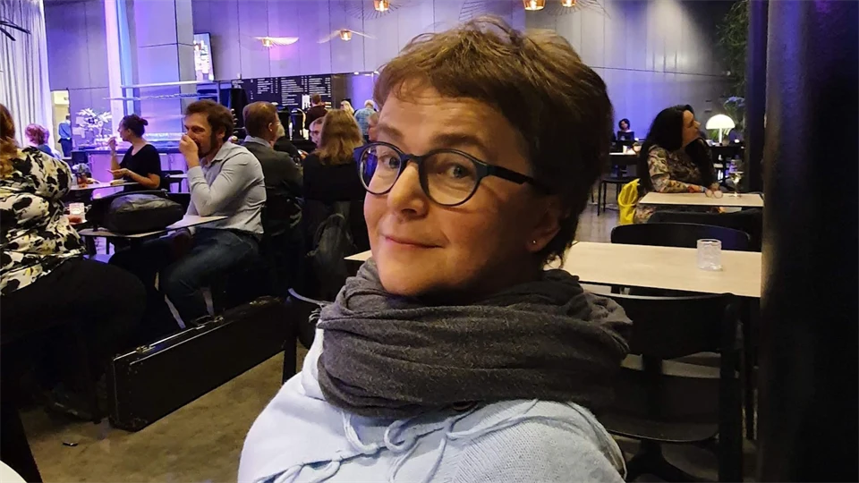 en kvinna med glasögon som sitter på en restaurang