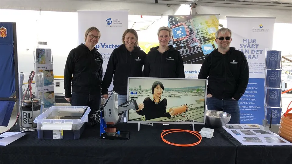 Four people working in Mid Sweden University exhibition stand.