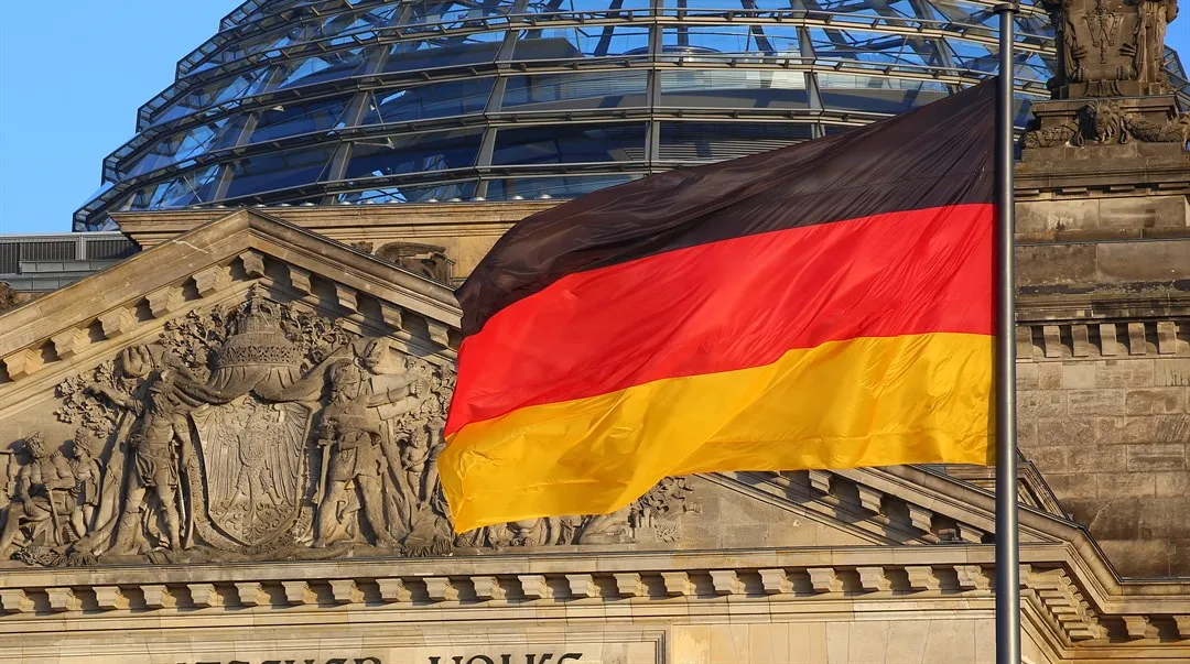 Tyskflagga framför en stenfasad.