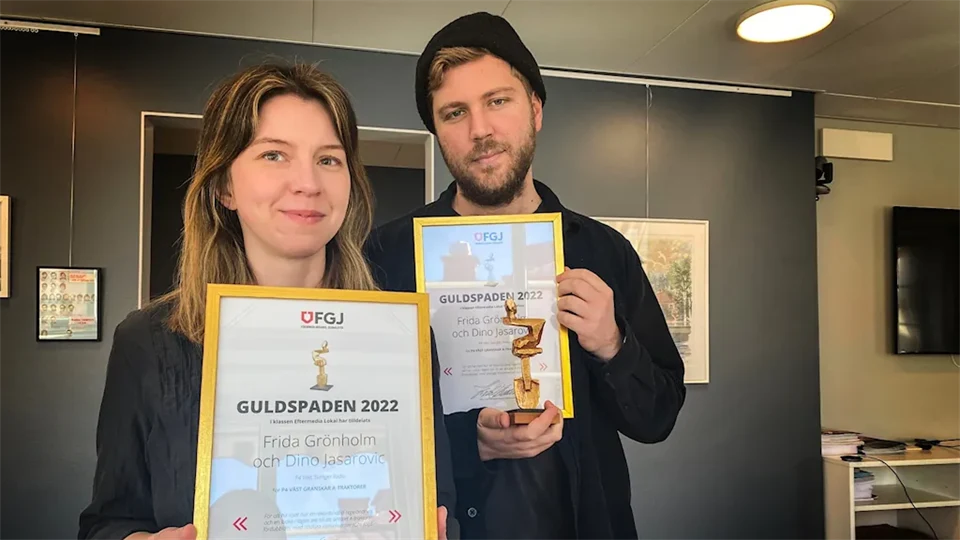 En kvinna och en man håller i varsitt guldigt diplom och en pokal