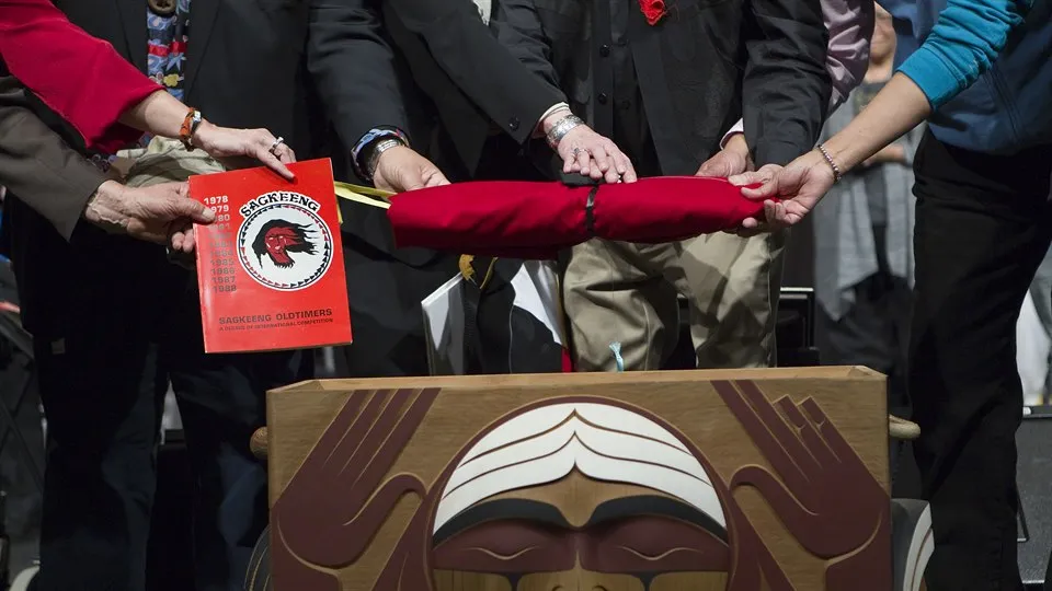 Fyra personer håller i en bok och en röd flagga