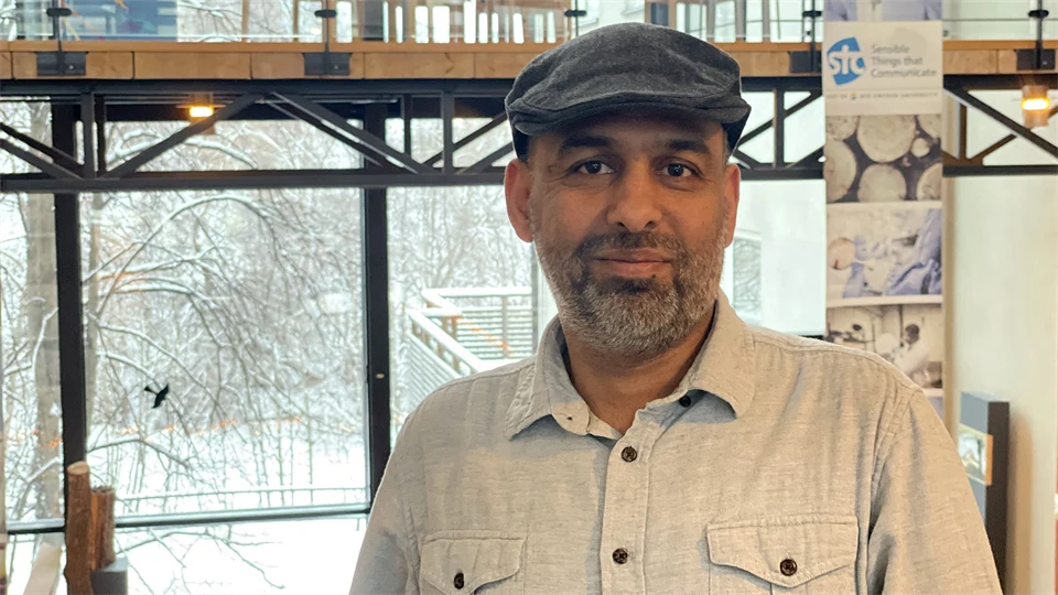 Man in gray cap and light shirt poses in front of the camera.