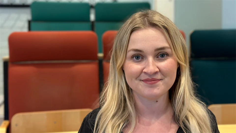 Ett porträttfoto av en blond kvinna med hår över axlarna