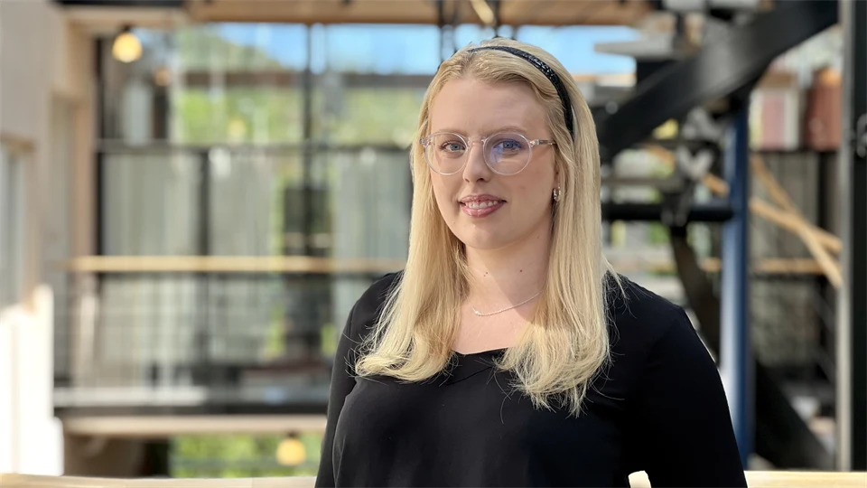 A blonde woman with glasses and a black sweater