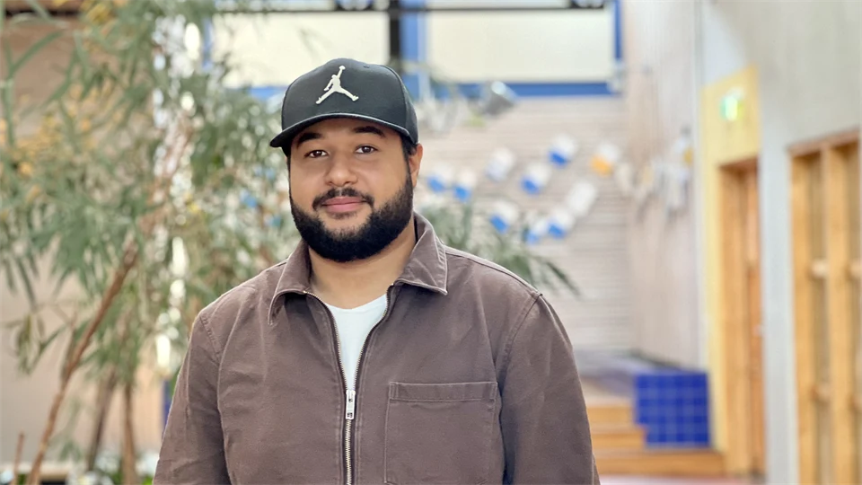 A man with a beard and a hat and a brown sweater