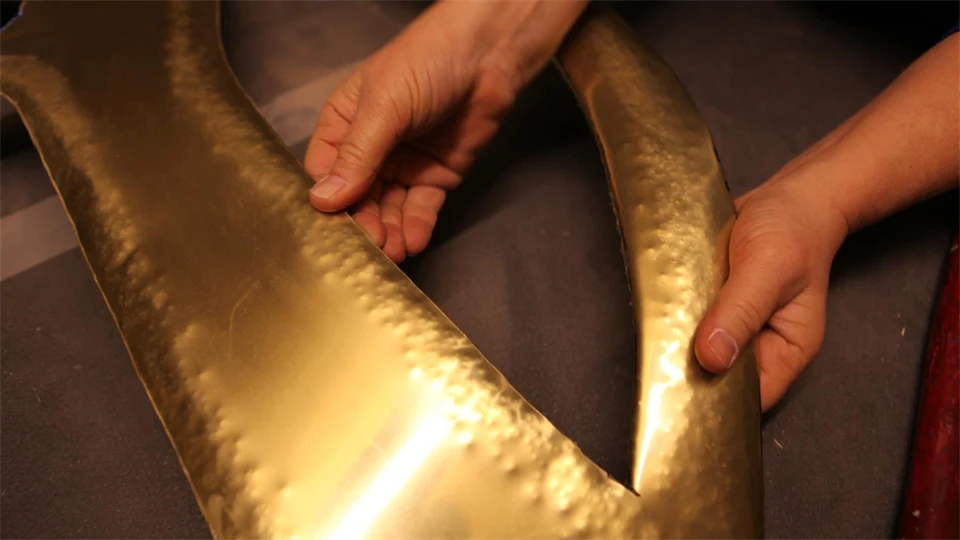 Hand och konstverk i mässing 