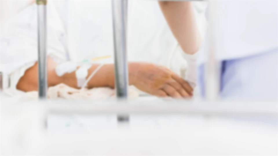 blurry photo of patient on bed with nurse take care 