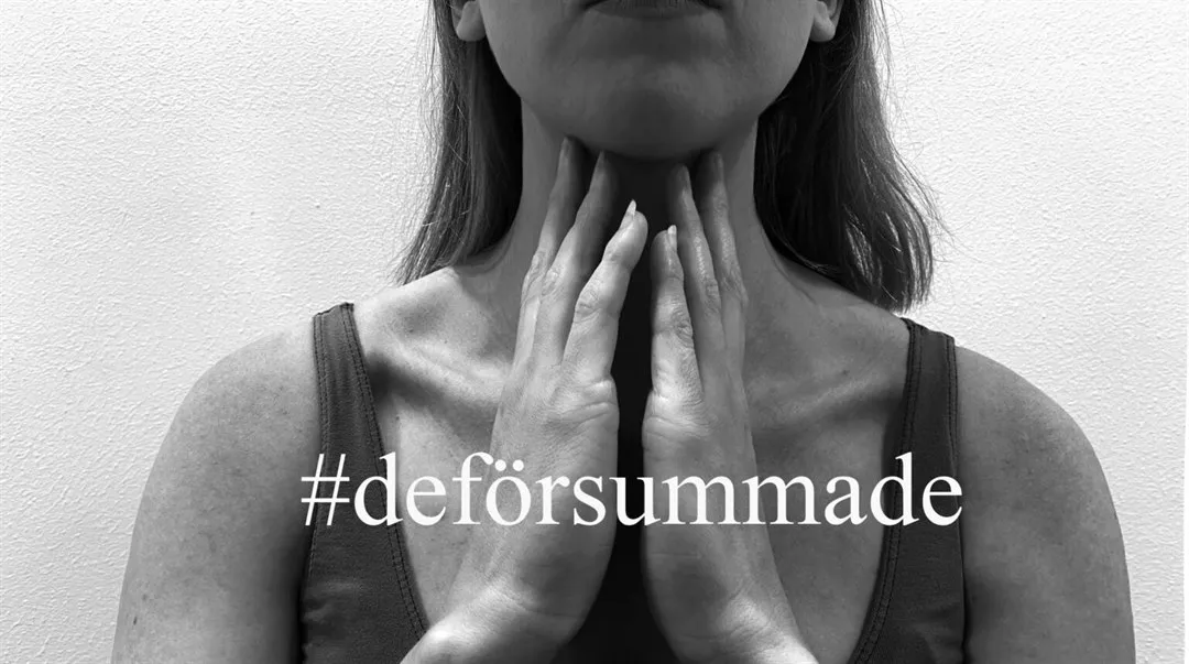 En kvinna som håller händerna mot hakan