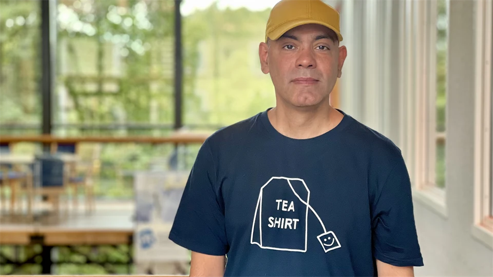 A man with a tshirt and a yellow hat