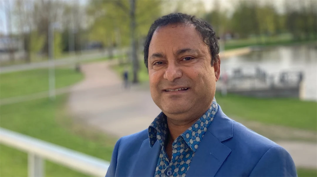 Koustuv Dalal står utomhus framför en parkmiljö.