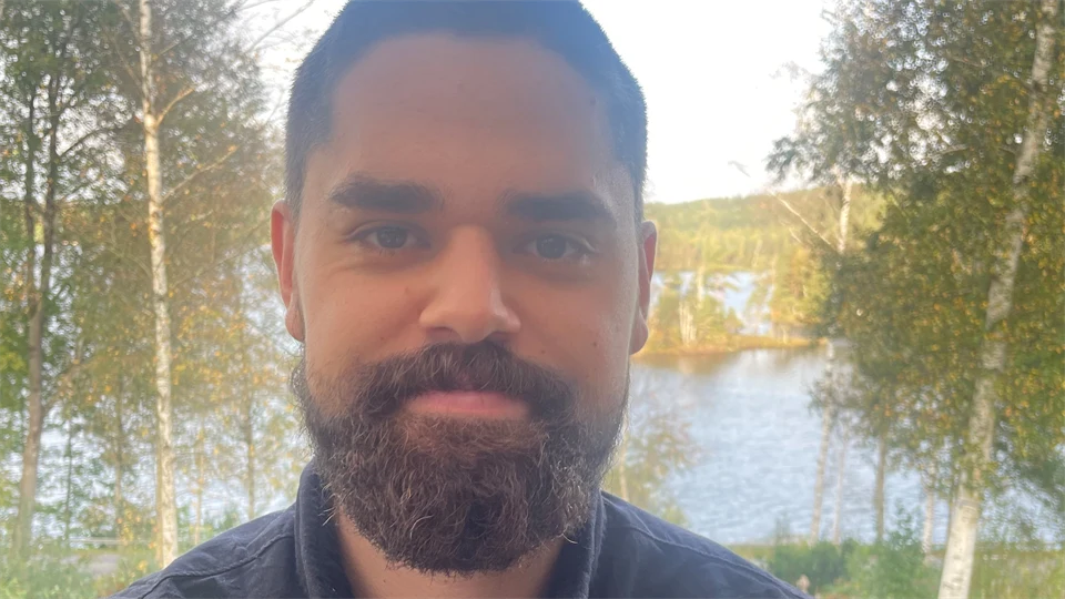 En man med skägg och svart skjorta