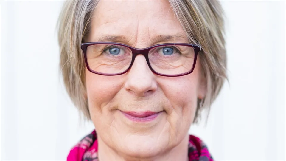 Lena Runius, en kvinna med rosa glasögon och blus