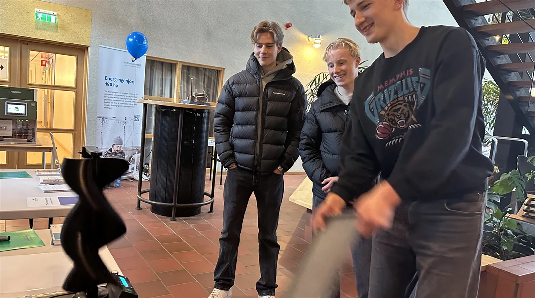 Tre män tittar på ett bord