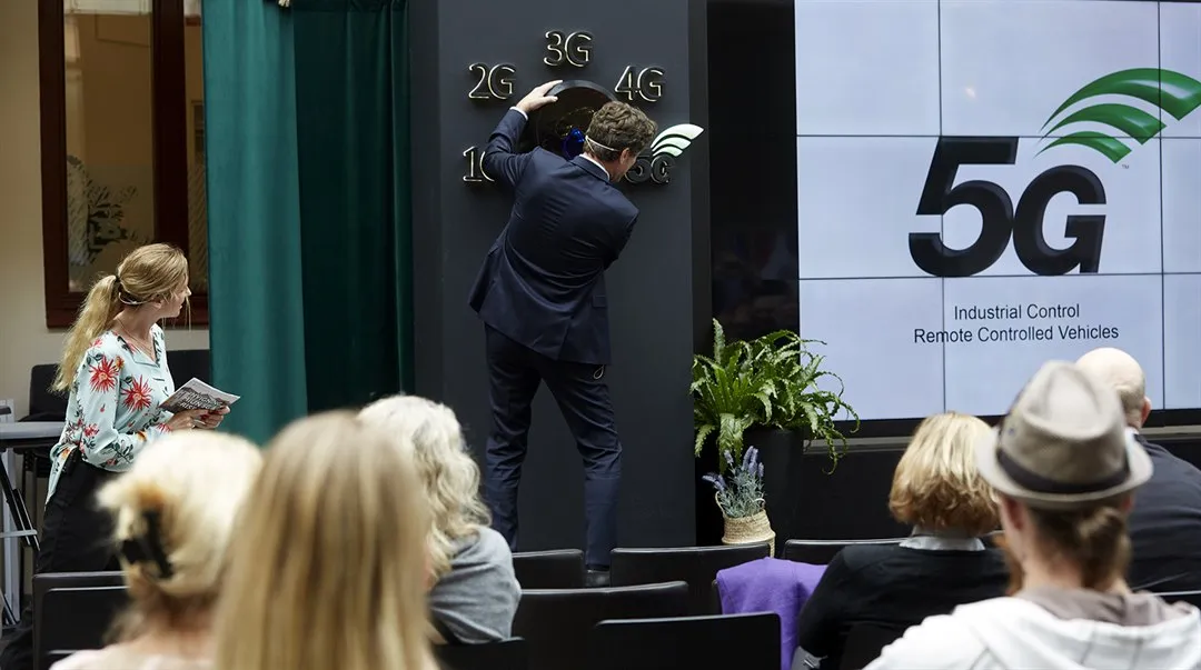 Man turning a big switch to launch 5G.