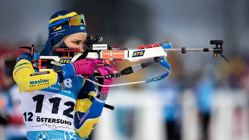 Skidskytten Stina Nilsson står och skjuter mot tavlan i WC-premiären i Östersund.