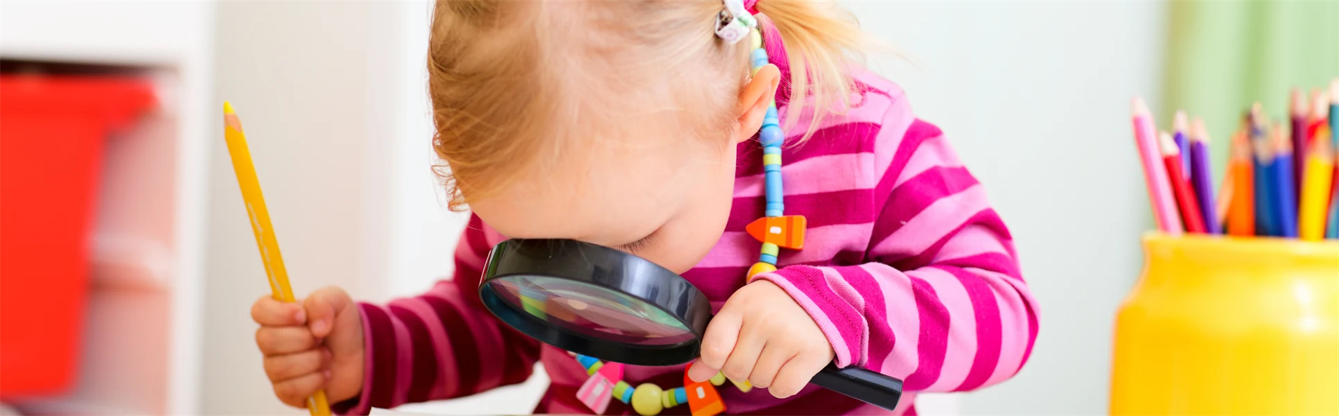 Förskolebarn tittar i förstoringsglas