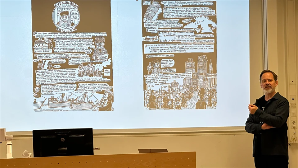 en svartklädd man står framför en projektorskärm