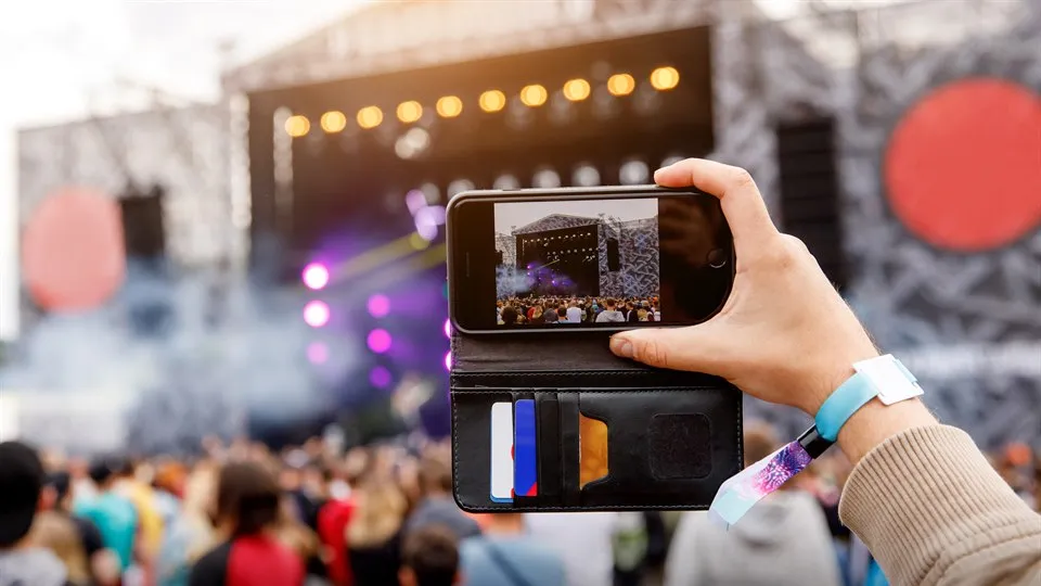 person spelar in konsert med mobilen, utomhusscen